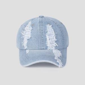Close-up of light blue denim baseball cap featuring vintage distressed ripped hole texture