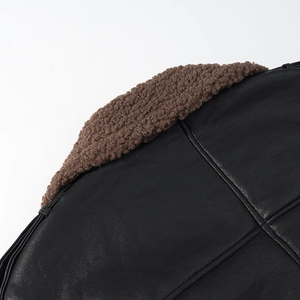 Detailed close-up of premium black leather grain and brown faux fur lining with stitching