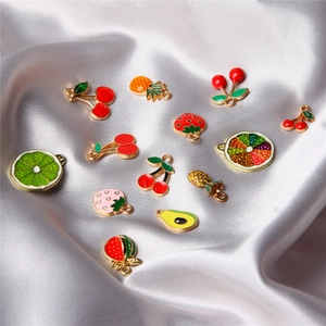 Mini fruit charms in colorful enamel for DIY jewelry making on purple silk fabric