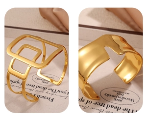 Detailed view of two gold asymmetric open bangles with high-polish finish and geometric design