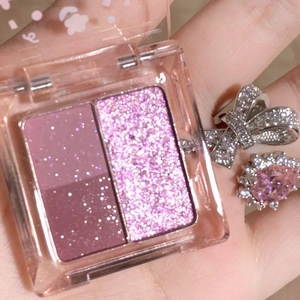 Dettaglio della palette ombretti bicolore con riflessi rosa e glitter viola accesi