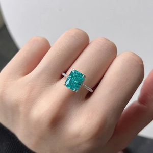 Detail of a large rectangular teal gemstone ring with pave diamonds on silver band