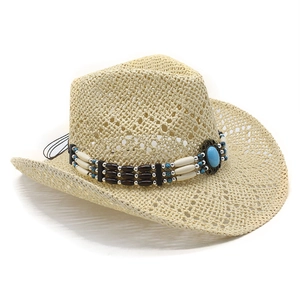 Detail of hollow-out straw cowboy hat with ethnic beaded band and turquoise stone