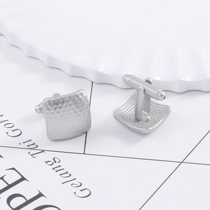 Close-up of matte silver square cufflinks with hammer pattern and T-bar swivel closure