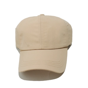 Dettaglio delle cuciture e del tessuto ad asciugatura rapida del cappellino da baseball beige