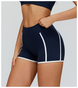 Detail view of high-waisted navy blue yoga shorts with white piping and elastic fabric