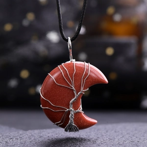 Macro shot of red goldstone moon pendant with wire-wrapped tree of life design