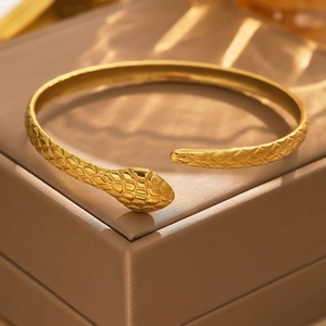 Detailed close-up of 18k gold plated snake-shaped cuff with engraved scale textures