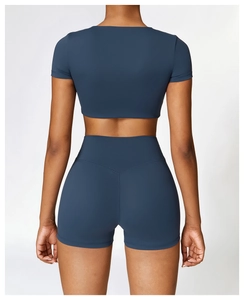 Rückansicht eines elastischen blaugrauen Yoga-Crop-Tops und passender Shorts am Modell