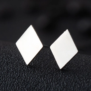 Macro view showing the polished mirror finish on geometric stainless steel diamond studs