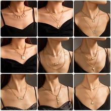 Detailed view of multiple layered gold and silver necklaces with punk-style pendants