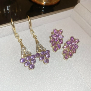 Goldene Ohrringe mit lila Kristallen in Traubenform und Blumenform mit Glanzeffekt
