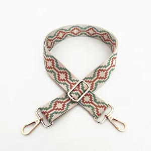 Close-up of geometric ethnic woven bag strap with golden metal swivel hooks and buckles
