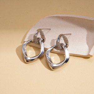 Detailed view of silver interlocking geometric earrings featuring sparkling zircon accents
