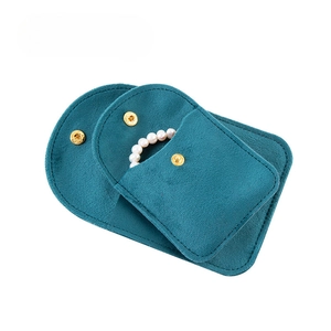 Peacock green velvet jewelry pouch with gold snap button and white pearl necklace