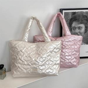 Detail of heart quilted tote bags in creamy white and pink on a stylish countertop