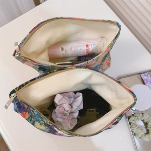 Close-up of floral cotton makeup bags with gold zippers and canvas lining detail
