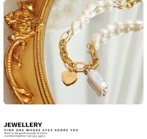 Detail of French style freshwater pearl and gold heart necklace on vintage mirror