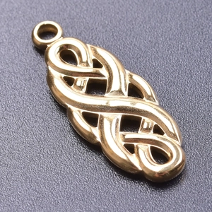 Macro shot of gold-plated stainless steel Celtic knot pendant on black background