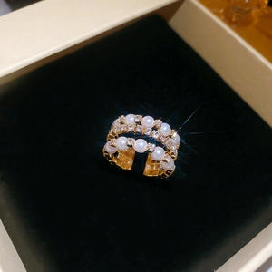 Detail of multi-layer gold ring with pearls and crystals in a luxury jewelry box