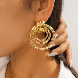 Close-up of gold layered concentric circle drop earrings on model for a trendy look