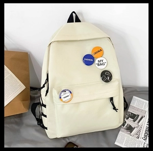 Close-up of cream white canvas backpack featuring trendy detachable fashion badges