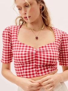 Detail of red and white checkered crop top featuring puffy sleeves and heart neckline