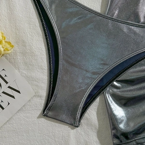 Detail shot of silver metallic bikini fabric and high-quality stitching on a white background