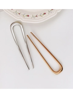 Detail of silver and gold U-shaped metal hairpins with smooth polished finish
