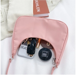 Pink nylon half-moon bag interior showing space for phone, sunglasses and cosmetics