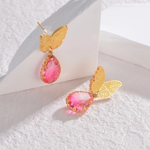 Bohemian gold butterfly earrings with pink crystal stones on a white background