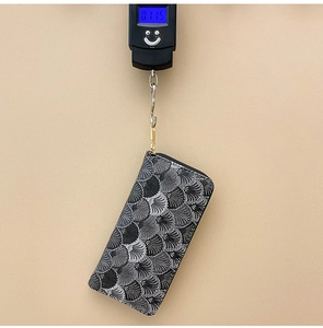 Detailed view of large capacity grey wallet weighing only 0.115kg on digital scale