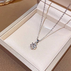 Gros plan d'un collier en acier titane argenté avec pendentif zircon dans sa boîte à bijoux