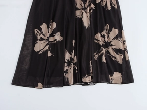 Detailed macro view of black mesh fabric featuring a large beige floral print on a long dress