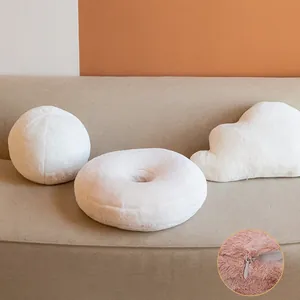 Plush faux rabbit fur pillow set with cloud and donut shapes on a soft living room sofa