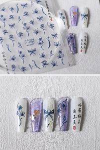 Macro shot of 5D blue ink floral and butterfly nail stickers with embossed textures