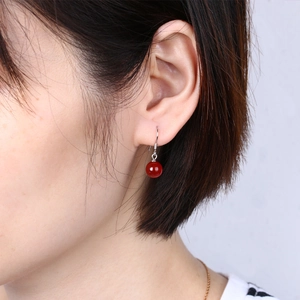 Close-up of red agate drop earrings on model's ear with S925 silver hooks detail