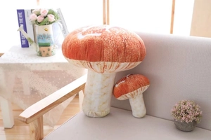 Macro view of realistic mushroom plush pillows in two sizes on a soft grey sofa
