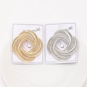 Detail of twisted spiral brooches in gold and silver finish on white jewelry cards