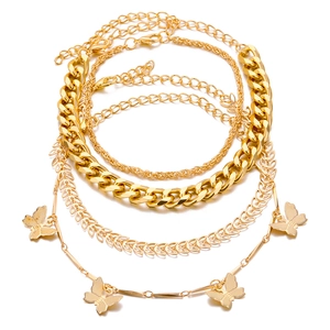 Set di quattro bracciali a catena cubana dorati con elegante ciondolo a farfalla