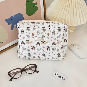 Detail view of white quilted cosmetic bag with cute dog prints and Sozakka label