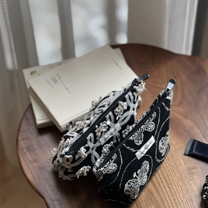 Linen canvas cosmetic bags with butterfly embroidery and lace flowers on wooden table