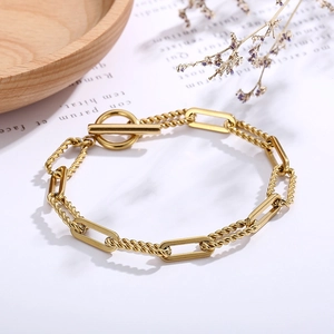 Detailed shot of golden link chain bracelet with OT toggle clasp on a minimalist background