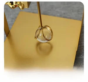 Detail of steady gold metal base and glass ball of a minimalist rabbit napkin holder
