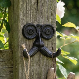 Gancho de pared vintage de hierro fundido con diseño de bigote sobre madera natural
