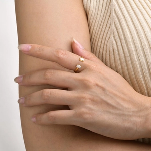 Close-up of a gold open ring with dual rectangular white zircon stones worn on hand