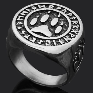 Detailed close-up of men's Viking rune ring with wolf paw symbol on black mirror background