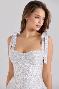 Close-up of white polka dot bustier top with shoulder ties and corset boning details