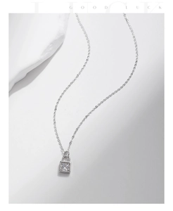 Macro view of a 925 sterling silver lock pendant necklace with a sparkling moissanite stone