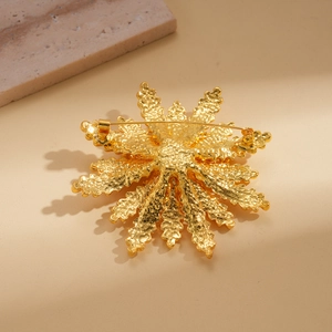 Back view of gold wheat flower brooch with pin clasp and hammered metal texture